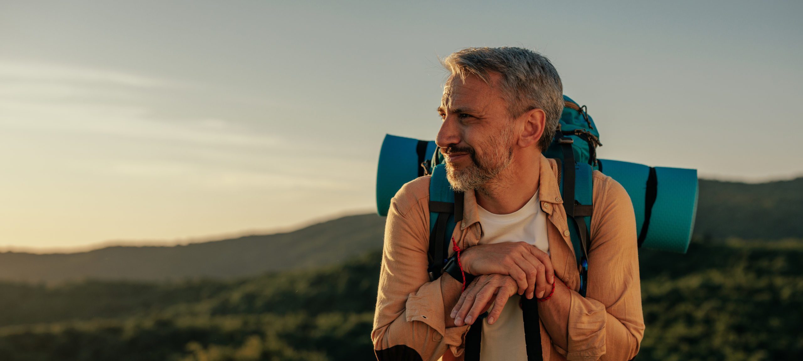 Male hiker walking on mountain with hiking poles