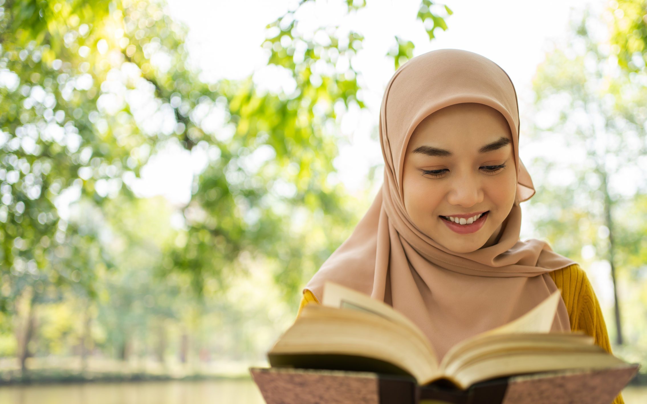Young Muslim woman reading and enjoying the fresh air in a green forest Enjoying the nature