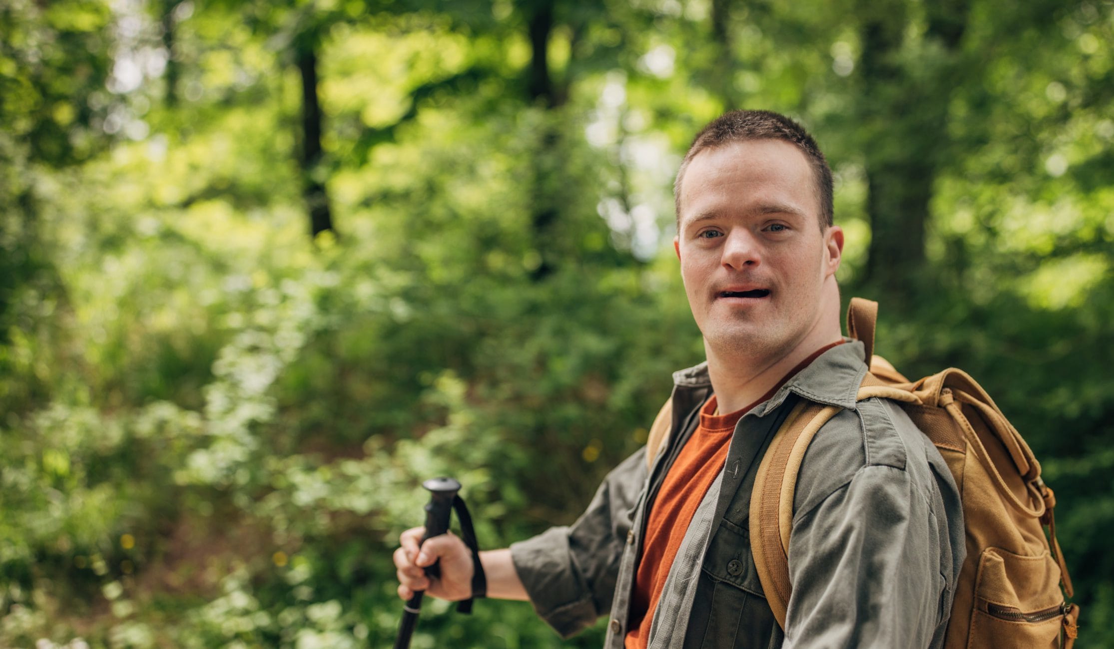 Young man with Down syndrome hiking in the forest