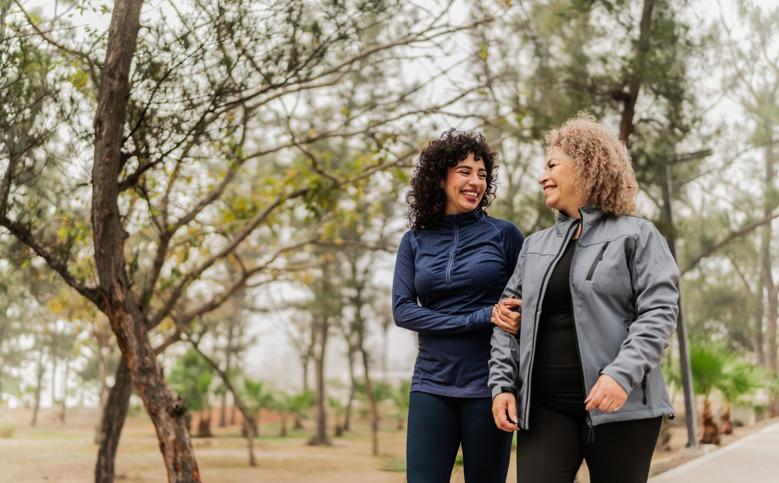 Mother and daughter talking while walking through the public park