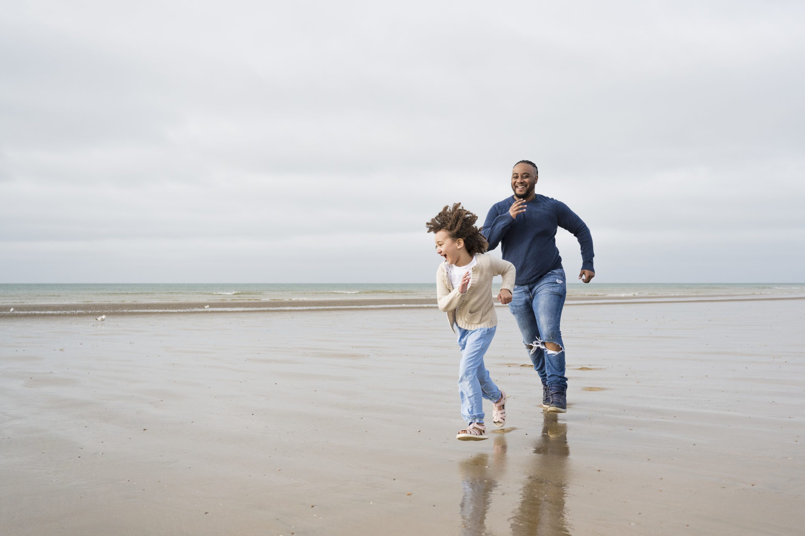 British father and young daughter playing at Camber Sands