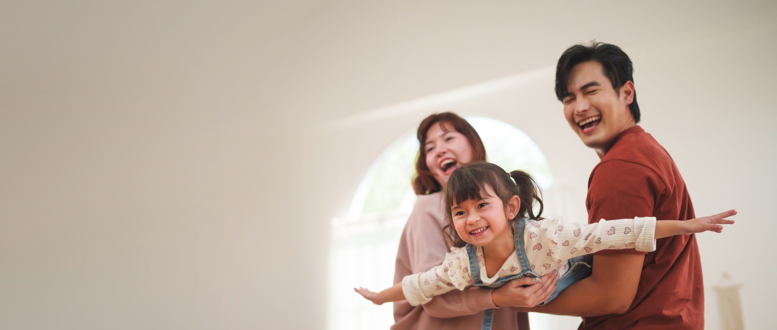 Asian parents playing with daughter at home
