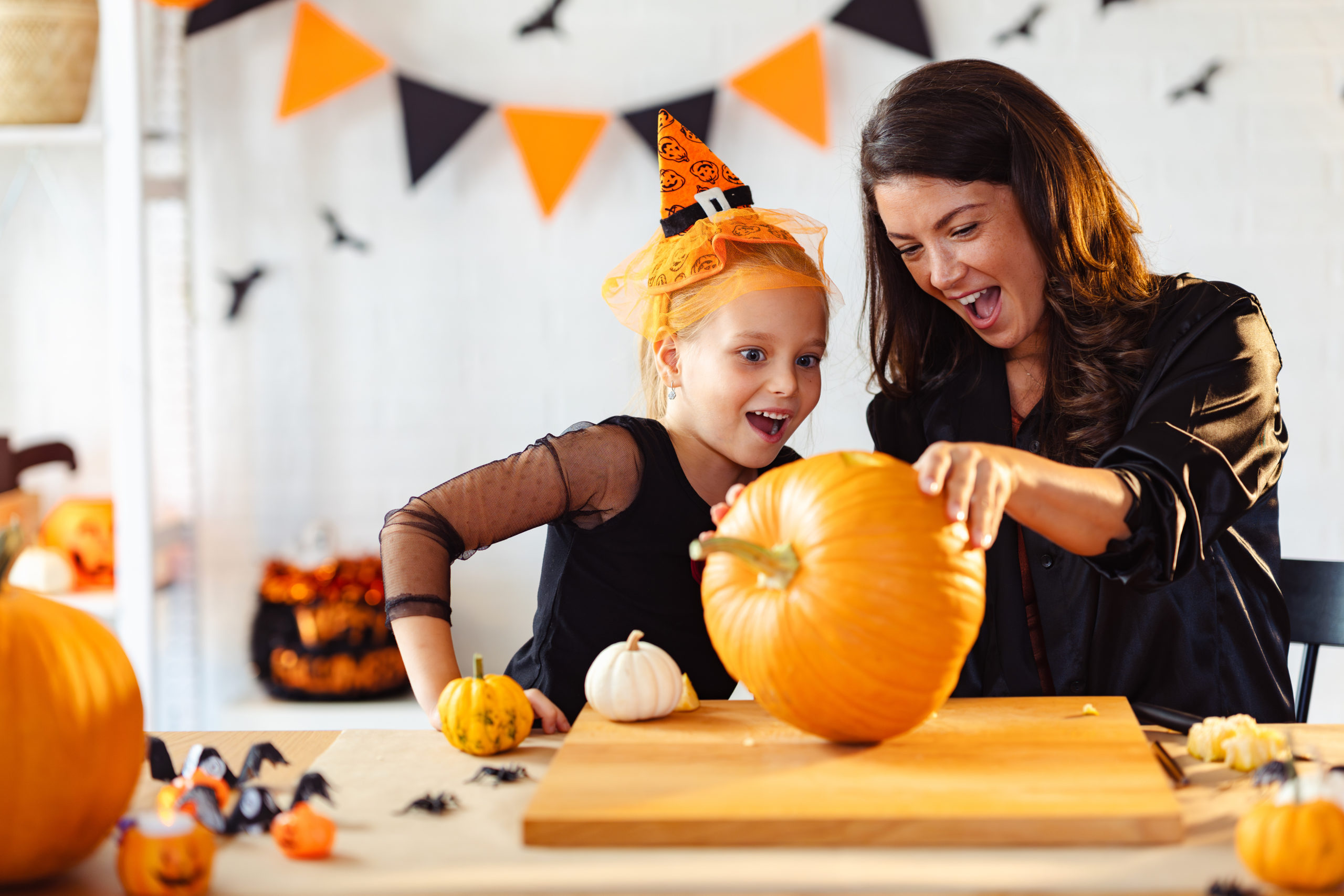 Mother and daughter carving pumpkin for Halloween